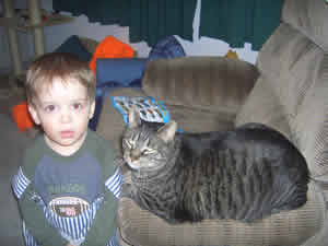 Buster the tabby cat sitting with his young friend